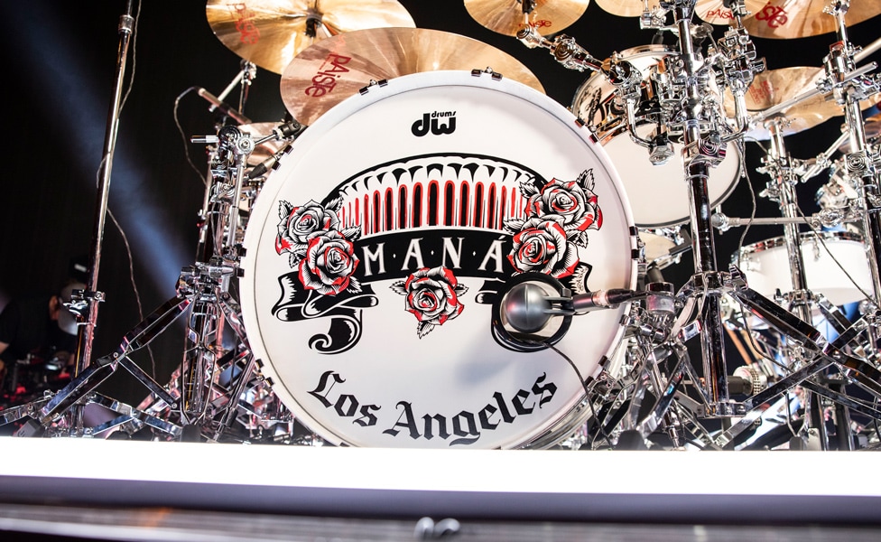 Alex González's bass drum head featuring the Maná logo