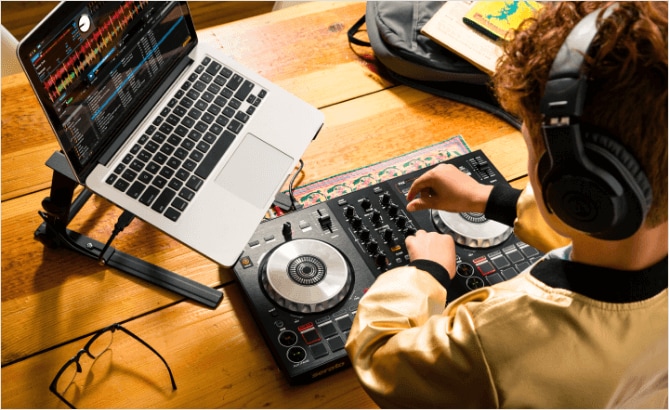 Boy with headphones learning how to DJ in class.
