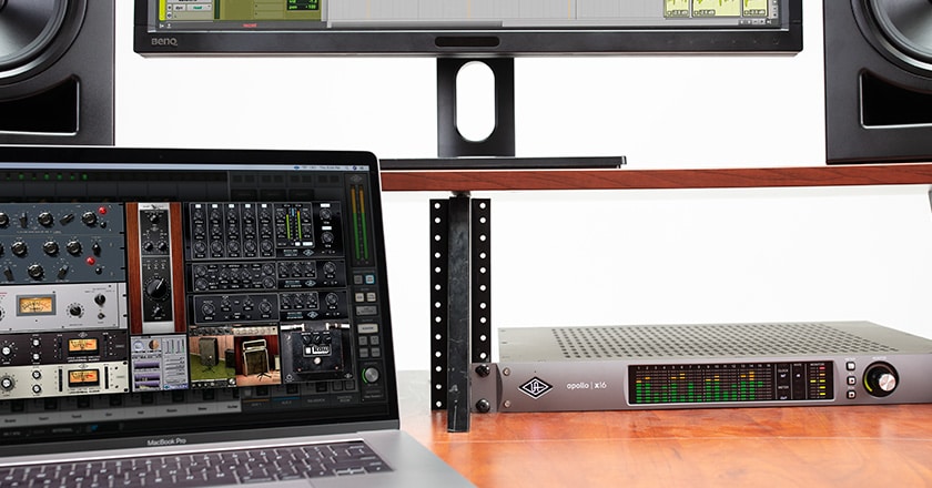 Apollo x16 rackmounted on a desk with UAD plugins on a laptop screen
