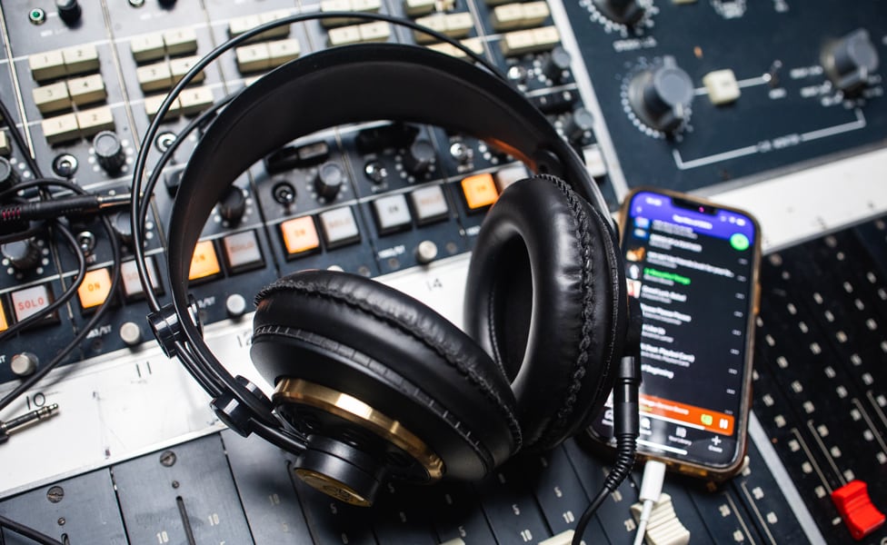 AKG Headphones and iPhone laying on mixing console