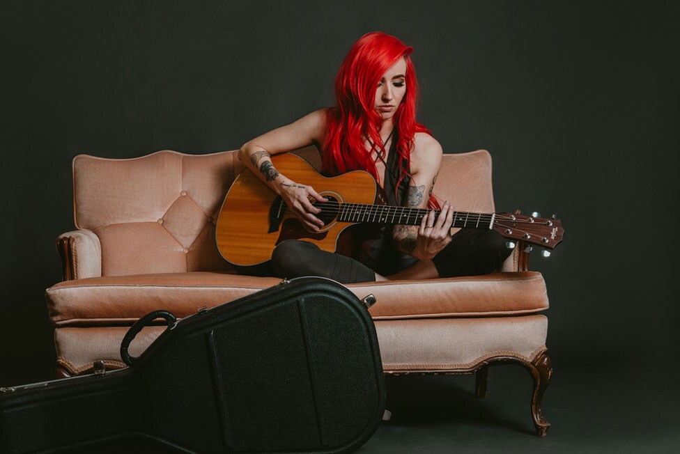 Lights sitting on a couch with her Taylor 700 Series 712ce