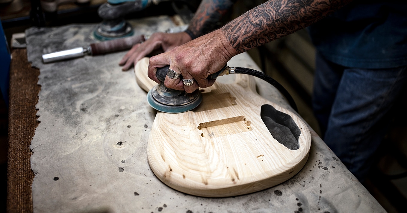 A Sander Works On An Ernie Ball Music Man Stingray Body