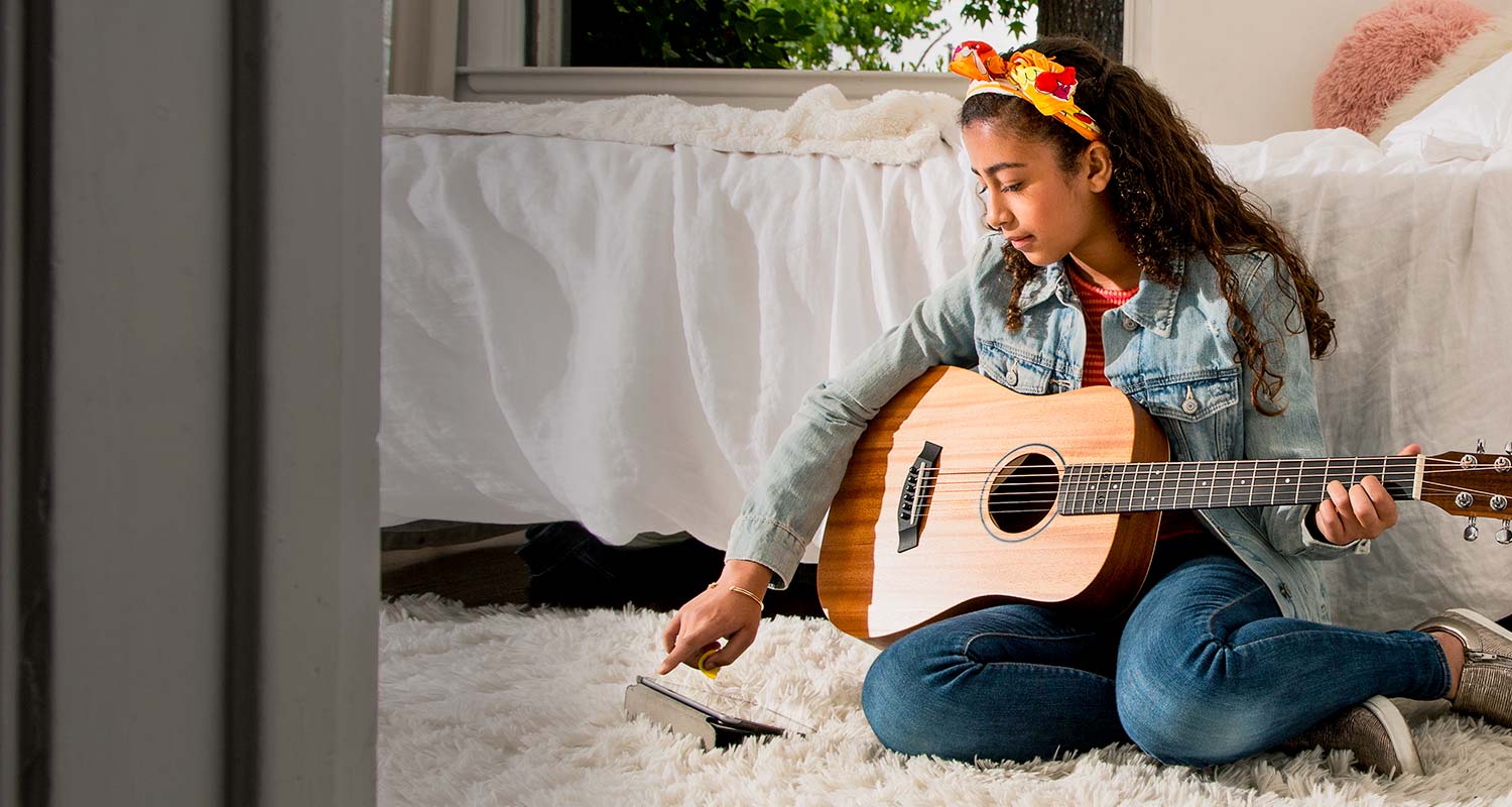 Enjoy Exclusive Offers. Teenage girl playing acoustic guitar.