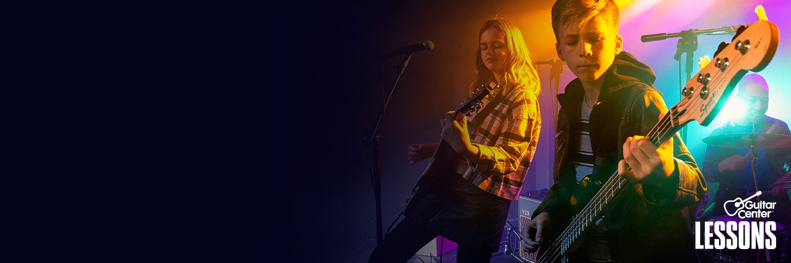 Man strumming electric guitar on stage.