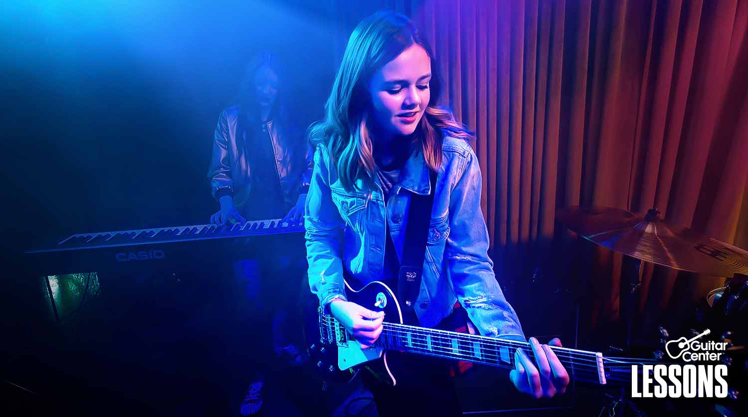 Boy and girl playing guitar in a band.