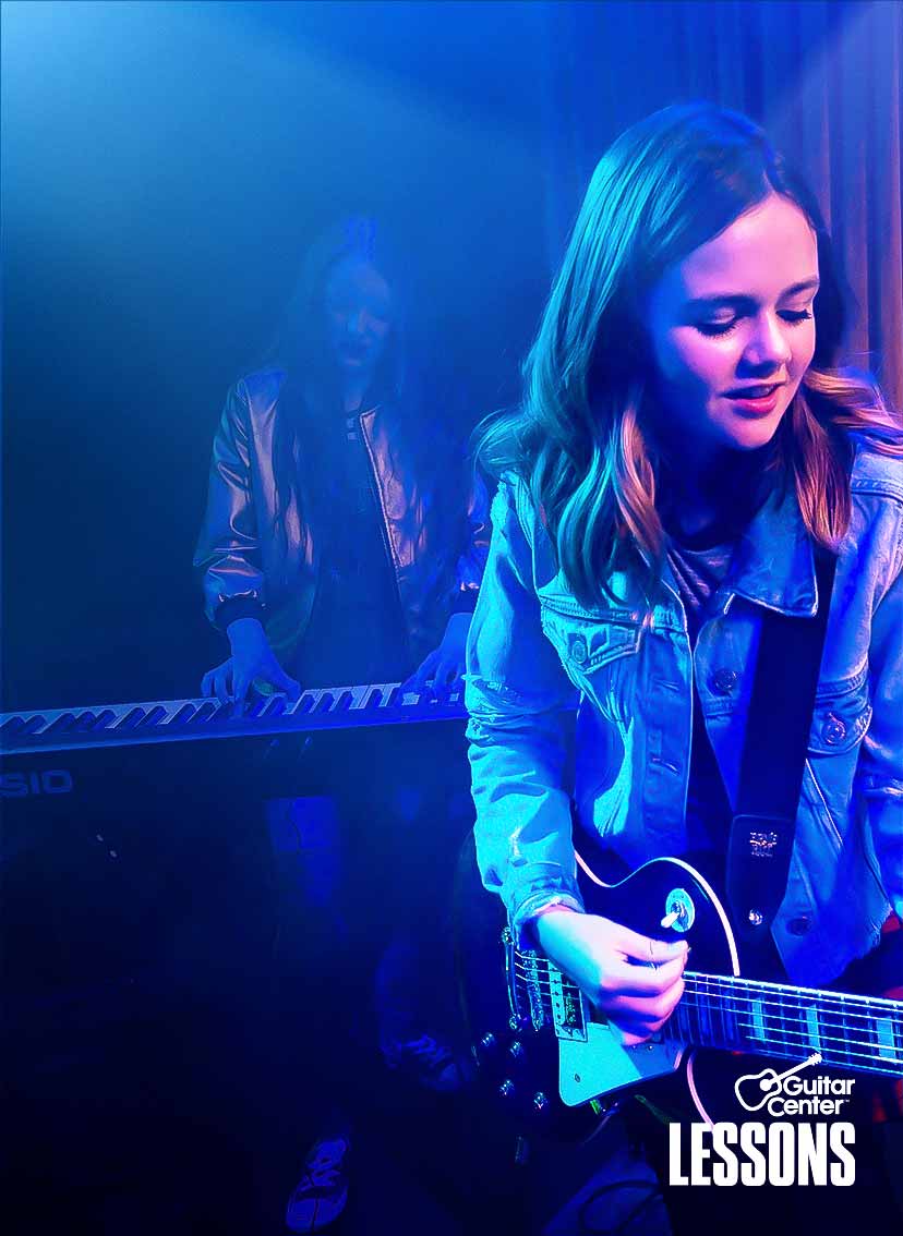 Boy and girl playing guitar in a band.