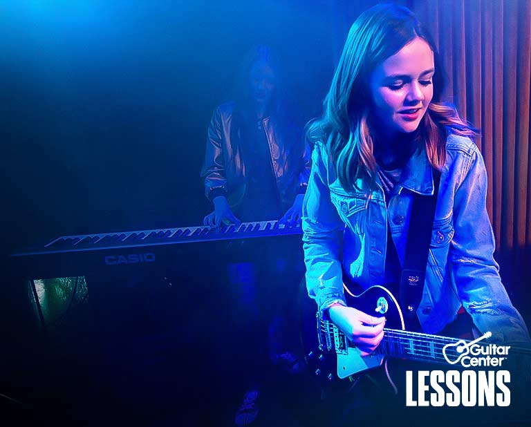 Boy and girl playing guitar in a band.